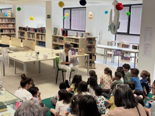 Carmen Aparicio leyendo a niños durante la presentación de su libro