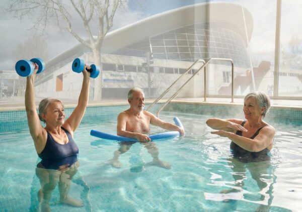 Personas mayores realizando ejercicios en piscina durante balneoterapia