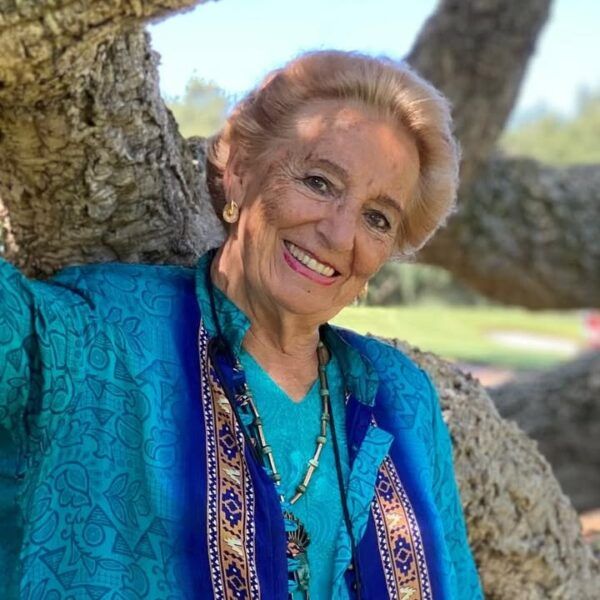 Retrato de Pilar Fernández Labrador sonriendo junto a un árbol.