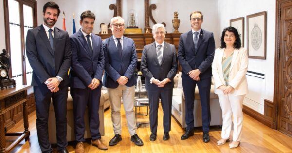 Reunión entre el secretario general de la USAL y el presidente de la Audiencia Nacional con asistentes.