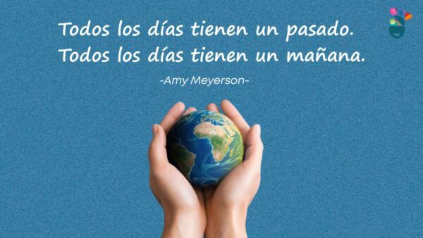 Manos sosteniendo un globo terráqueo con una cita inspiradora.