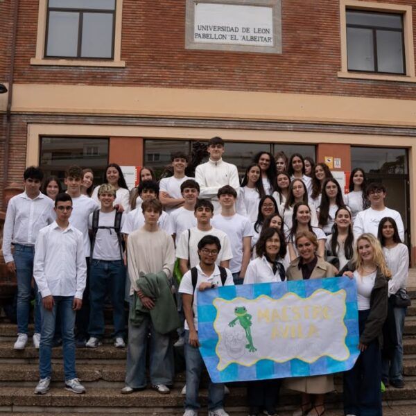 Grupo de estudiantes en la Universidad de León con cartel de Maestro Ávila