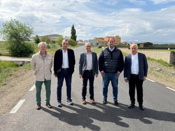 Grupo de personas en la carretera Campillo-Berrocal durante una visita oficial.