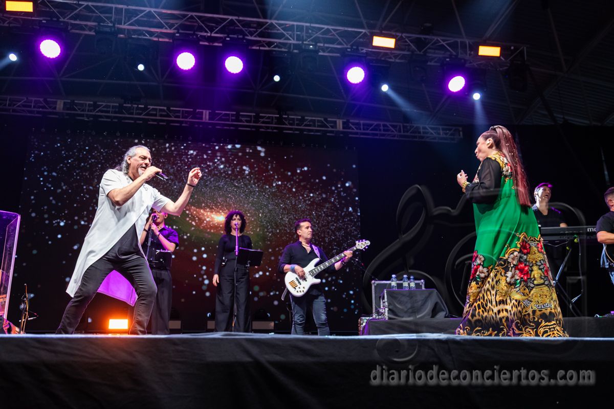 Camela en concierto, con luces y músicos en el escenario.