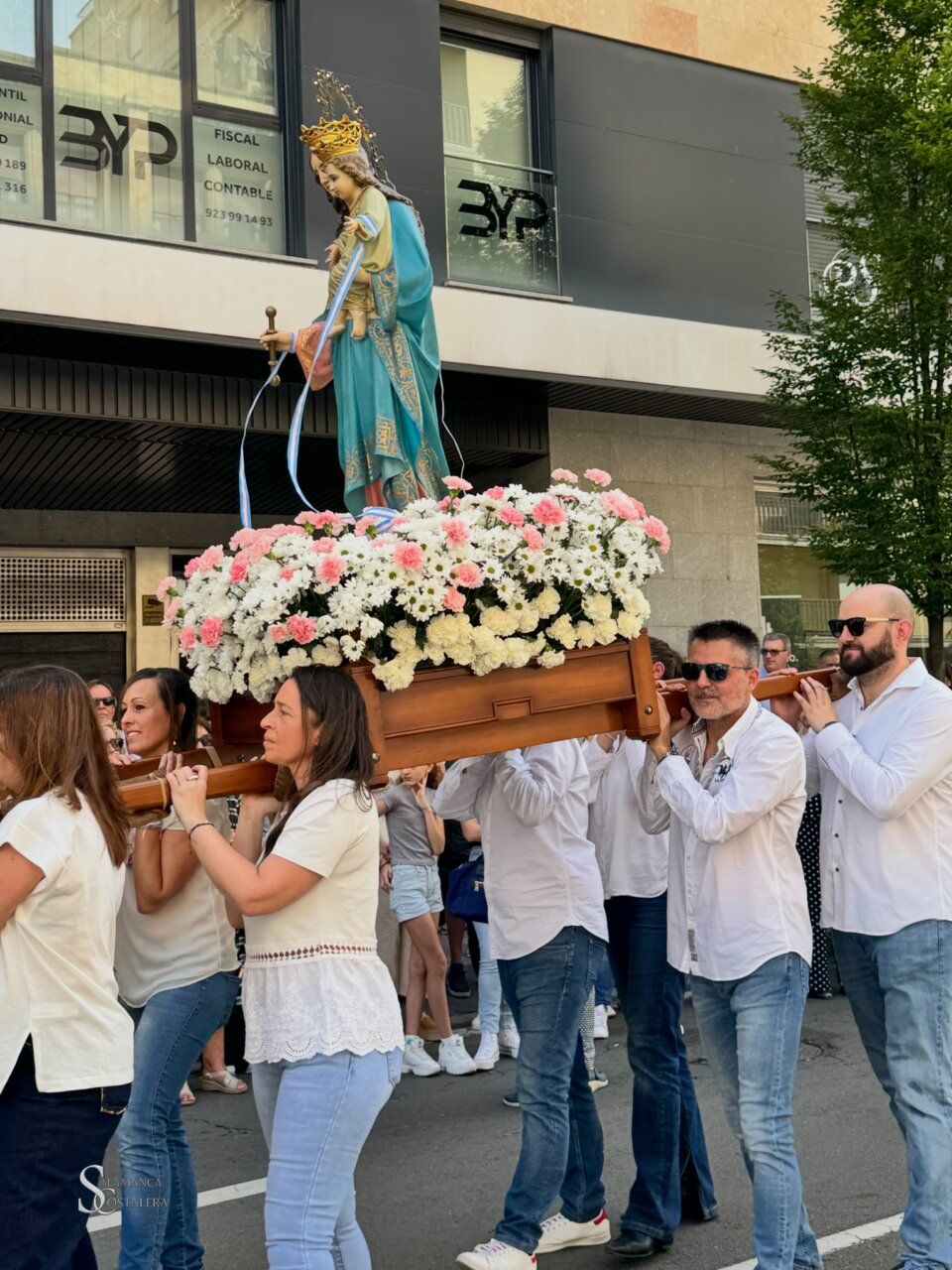 Procesión de María Auxiliadora en las calles de Salamanca con flores
