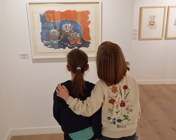 Dos niñas observando una obra de arte en un museo
