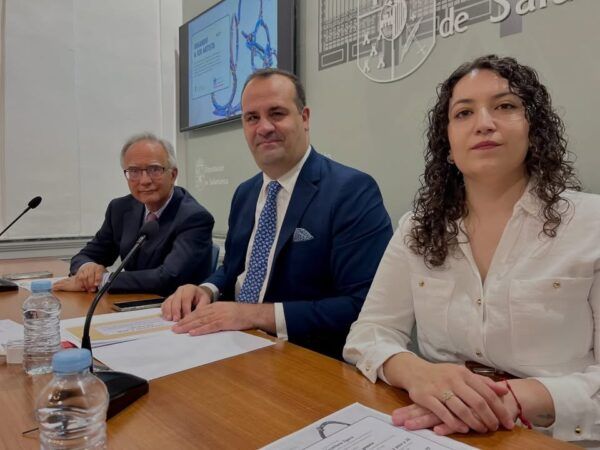 Tres personas en una mesa durante un evento sobre arte en Salamanca