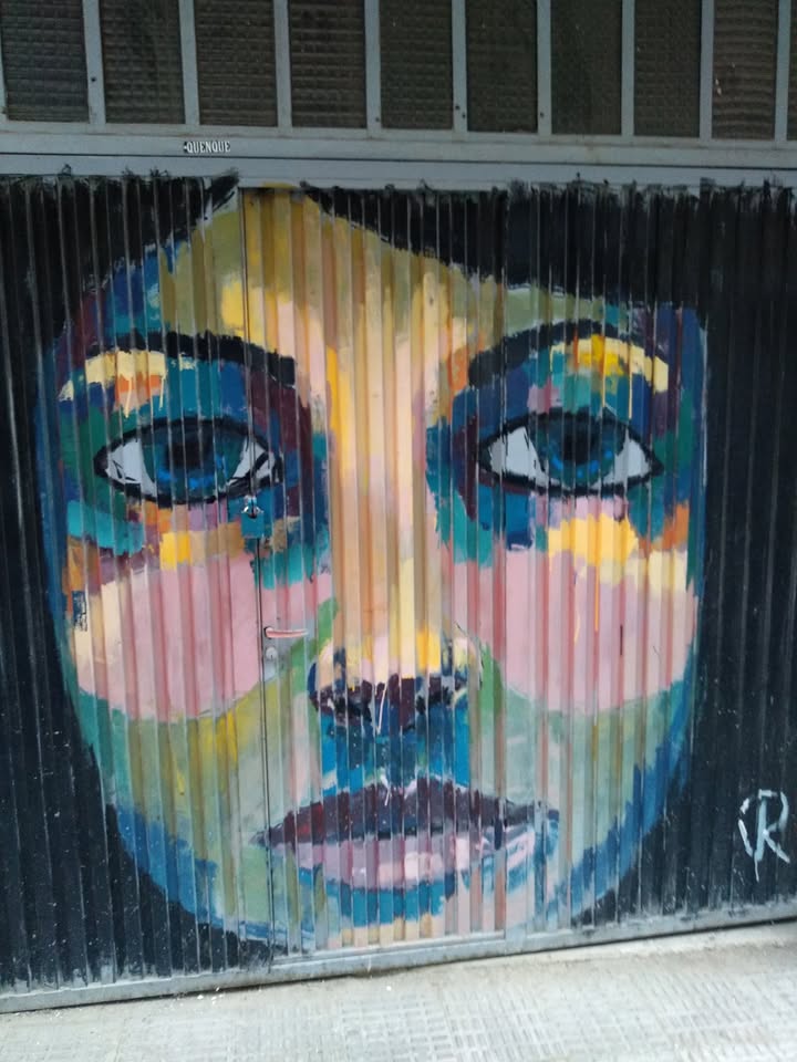 Mural colorido de un rostro en una puerta del barrio del Oeste en Salamanca