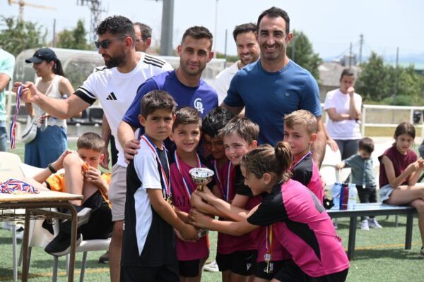 Niños celebrando con un trofeo en los campos de Toñete