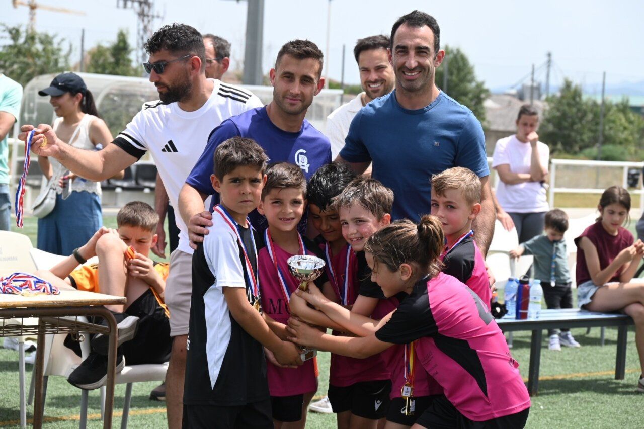 Niños celebrando con un trofeo en los campos de Toñete