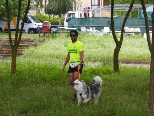 Participante del canicross de Alba de Tormes con un perro en un entorno verde