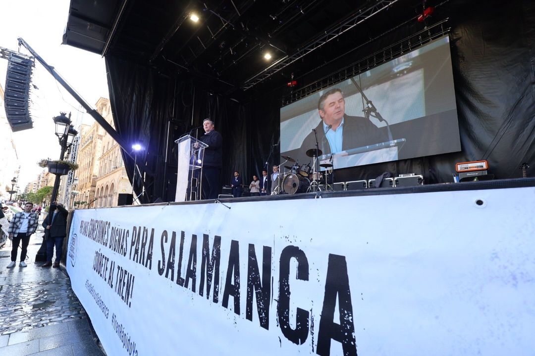 Concentración en Salamanca por mejoras en conexiones ferroviarias con un orador en el escenario.