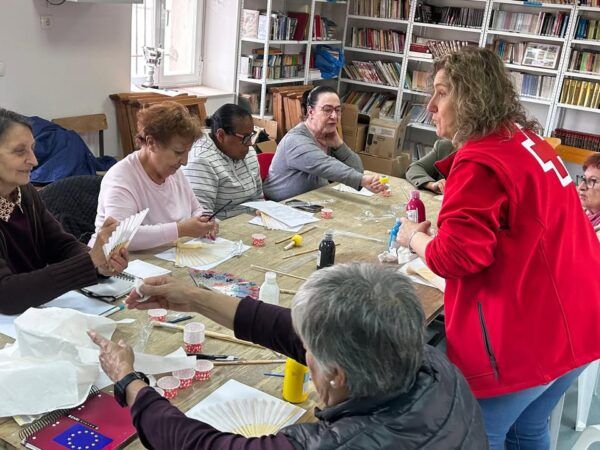 Grupo de personas participando en actividades manuales con Cruz Roja en Salmoral.