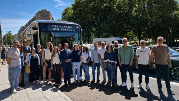 Grupo de personas junto a un autobús con lema del Día Mundial Sin Tabaco