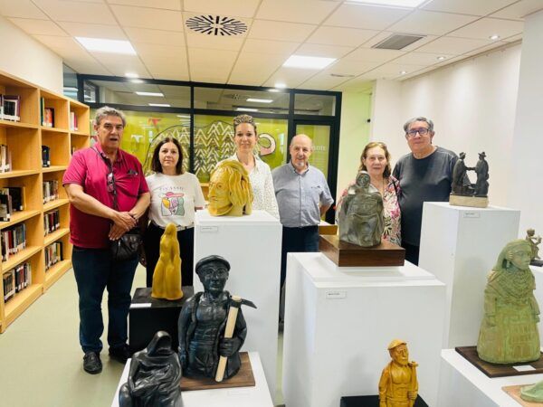 Grupo de personas en una exposición de cerámica en la biblioteca