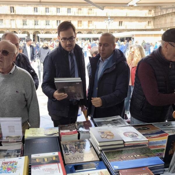 Personas revisando libros en la Feria del Libro en la Plaza Mayor