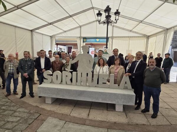 Grupo de personas en la II Feria de Artesanía de Sorihuela con un cartel de piedra