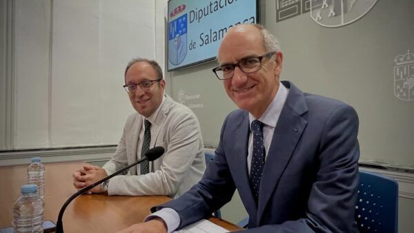 Dos hombres sonrientes en una reunión sobre financiación municipal en Salamanca