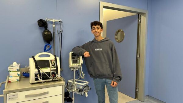 Estudiante de enfermería en un entorno clínico con equipos médicos.