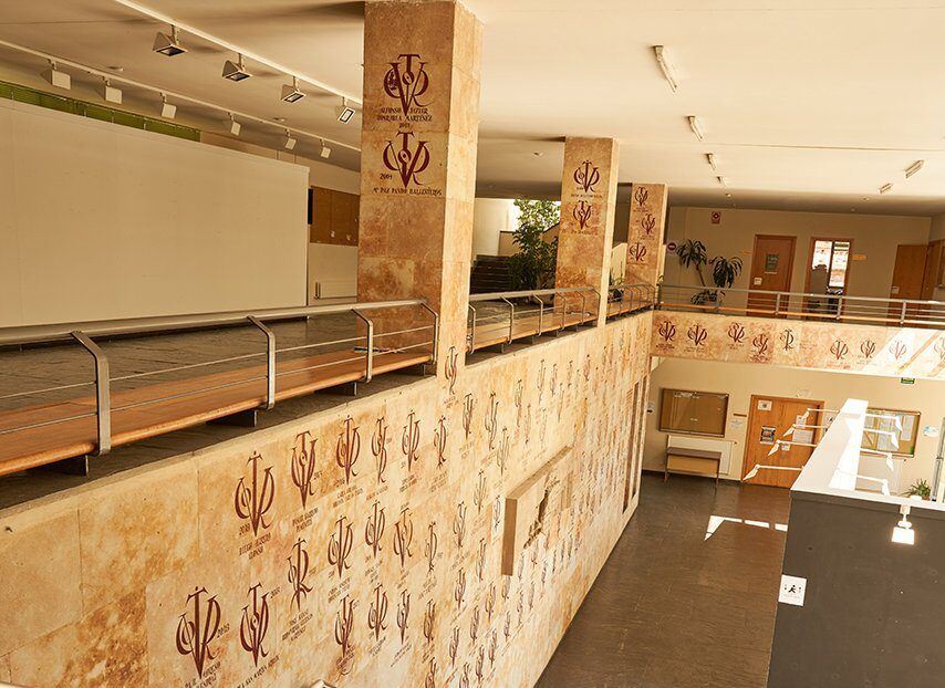 Interior de la Universidad de Salamanca con escaleras y paredes decoradas