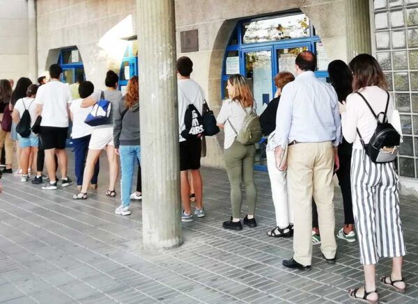 Grupo de personas haciendo fila para inscribirse en una escuela de idiomas