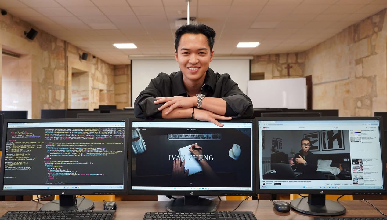 Estudiante Iván Zheng en un aula con computadoras mostrando código y proyectos