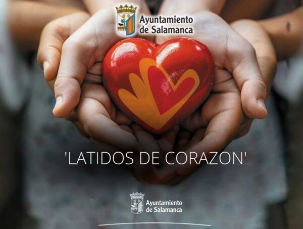 Manos sosteniendo un corazón rojo con un diseño colorido