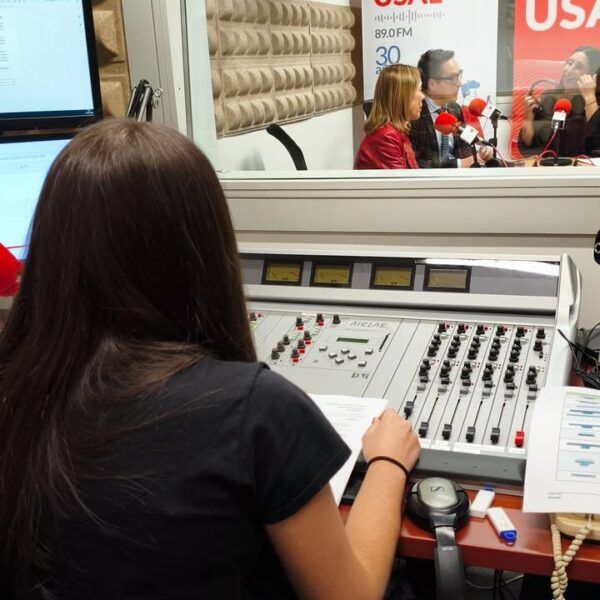 Persona en estudio de radio trabajando en la producción de un podcast
