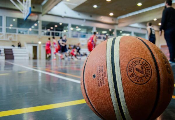 Balón de baloncesto en una cancha con jugadores en acción