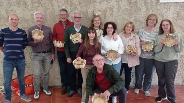 Participantes del taller de cestería sosteniendo cestas de mimbre