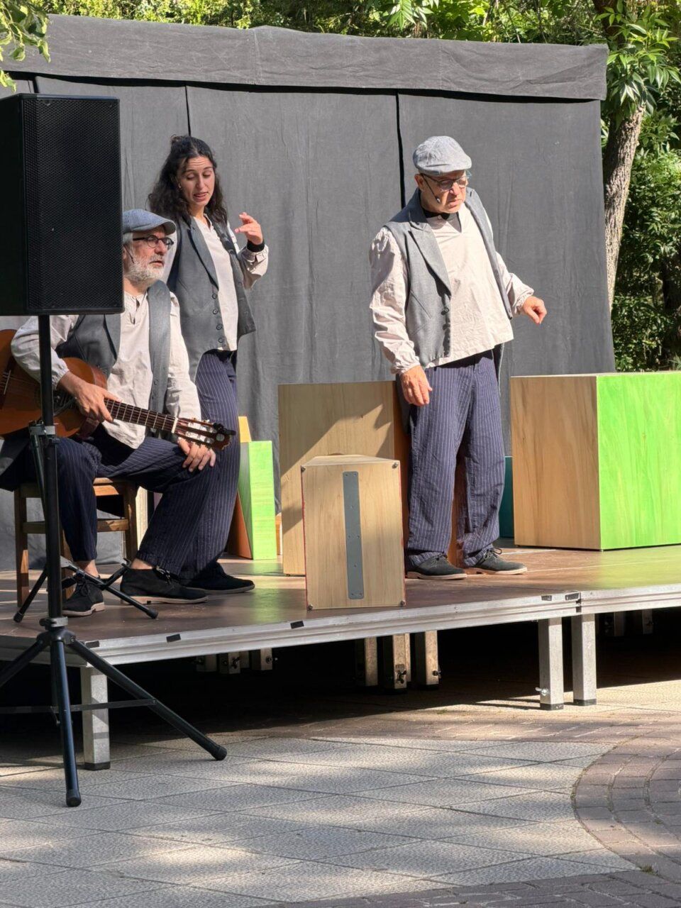 Actuación de teatro en un parque con tres artistas en escena