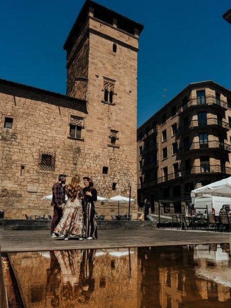 Grupo de personas conversando frente a la Torre del Aire en Fermoselle