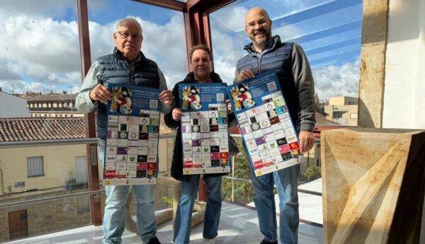 Tres personas sosteniendo carteles de los Premios Villamayor en un evento