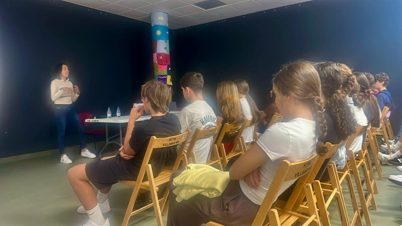 Estudiantes escuchando a una ponente en Villamayor sobre igualdad y deporte