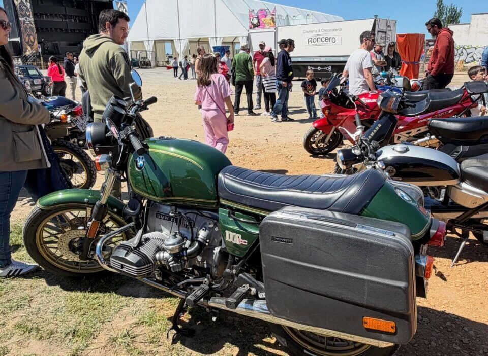 Motocicleta verde en el evento de Villamayor con gente alrededor