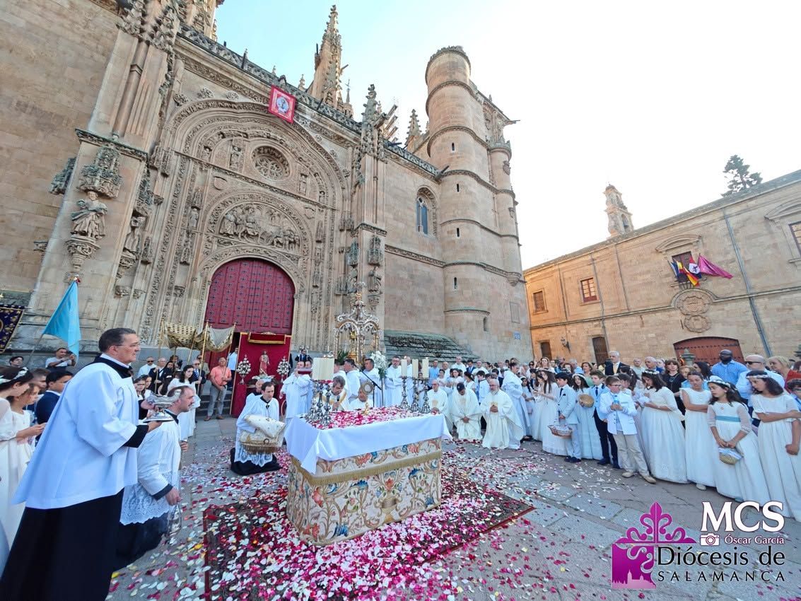 Procesión del Corpus Christi en Salamanca con la Catedral de fondo y fieles en la calle.
