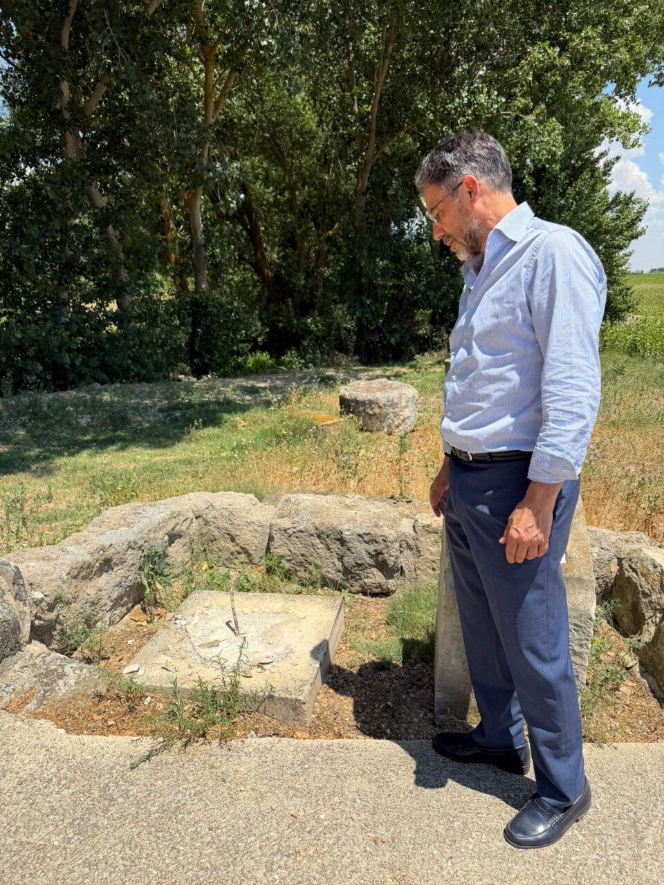 Hombre observando un monumento en Villamayor rodeado de naturaleza