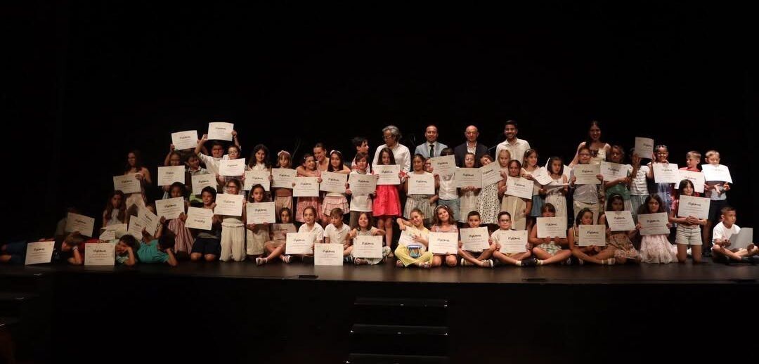 Alumnos de la Escuela Municipal de Música y Danza de Salamanca sosteniendo diplomas en una ceremonia