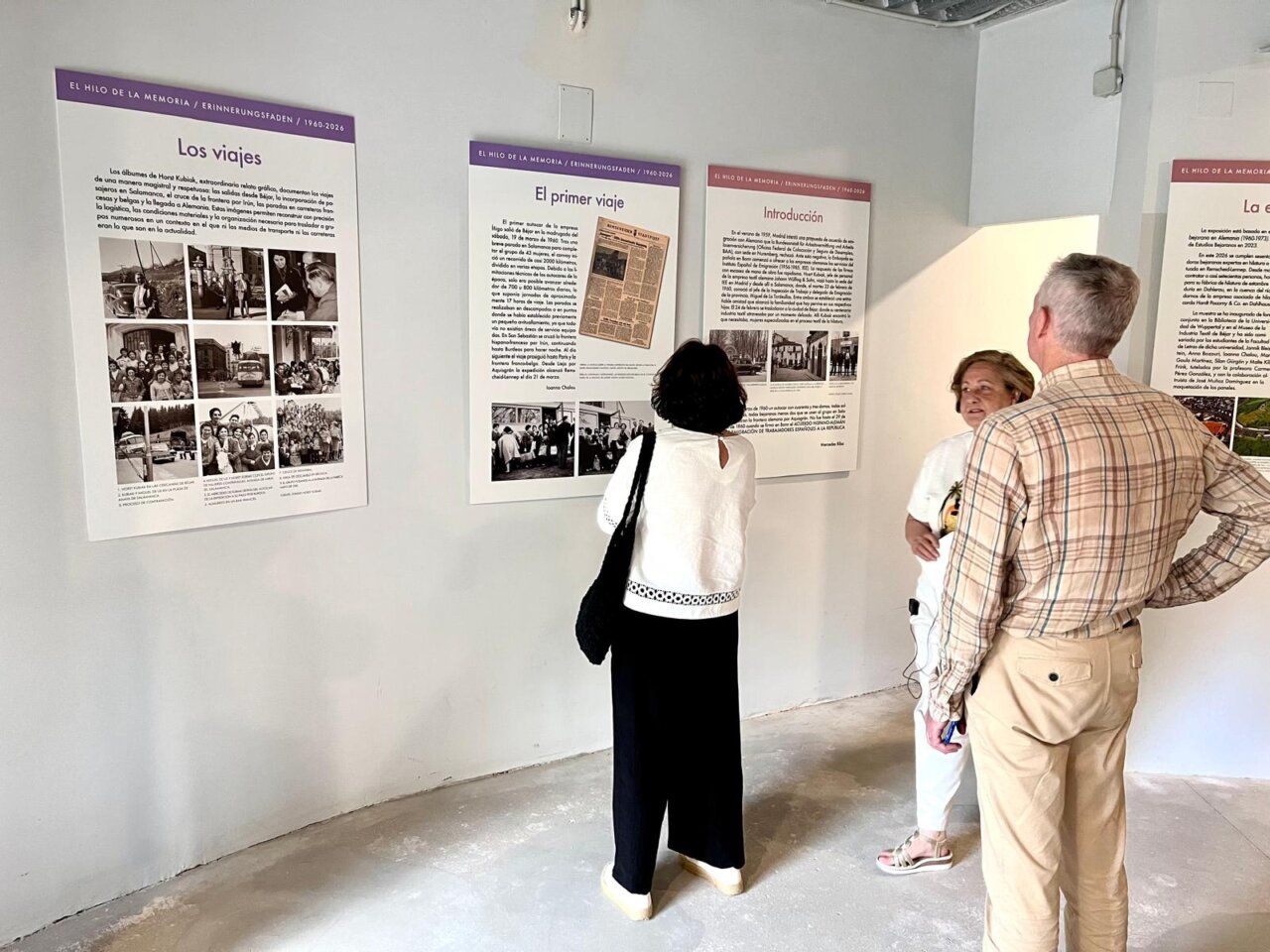 Visitantes observan paneles de la exposición sobre la emigración bejarana en Alemania.
