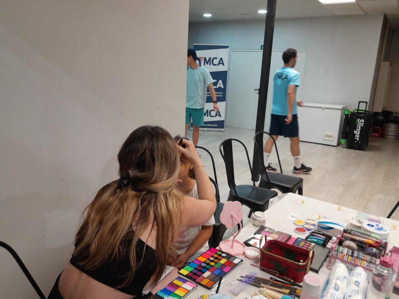 Niña recibiendo pintura facial en torneo de pádel YMCA