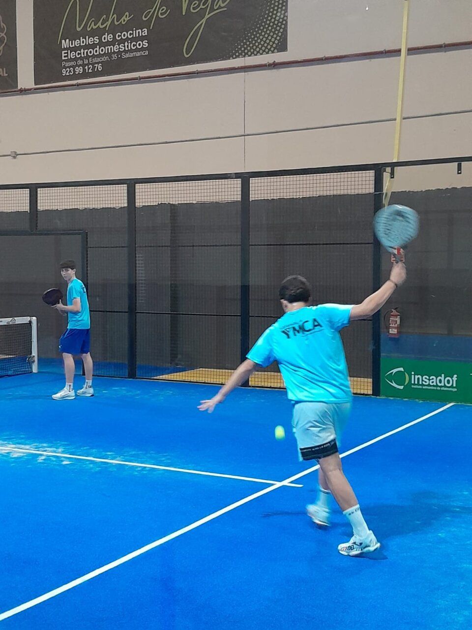 Jugadores en acción durante el torneo de pádel de YMCA