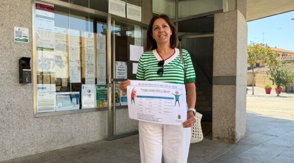 Mujer sosteniendo un cartel de actividades para mayores en Villamayor