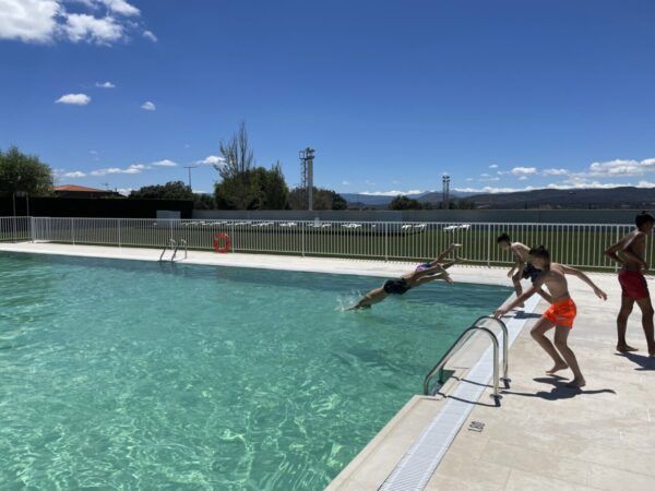 Niños disfrutando en la piscina municipal de Guijuelo bajo un cielo azul