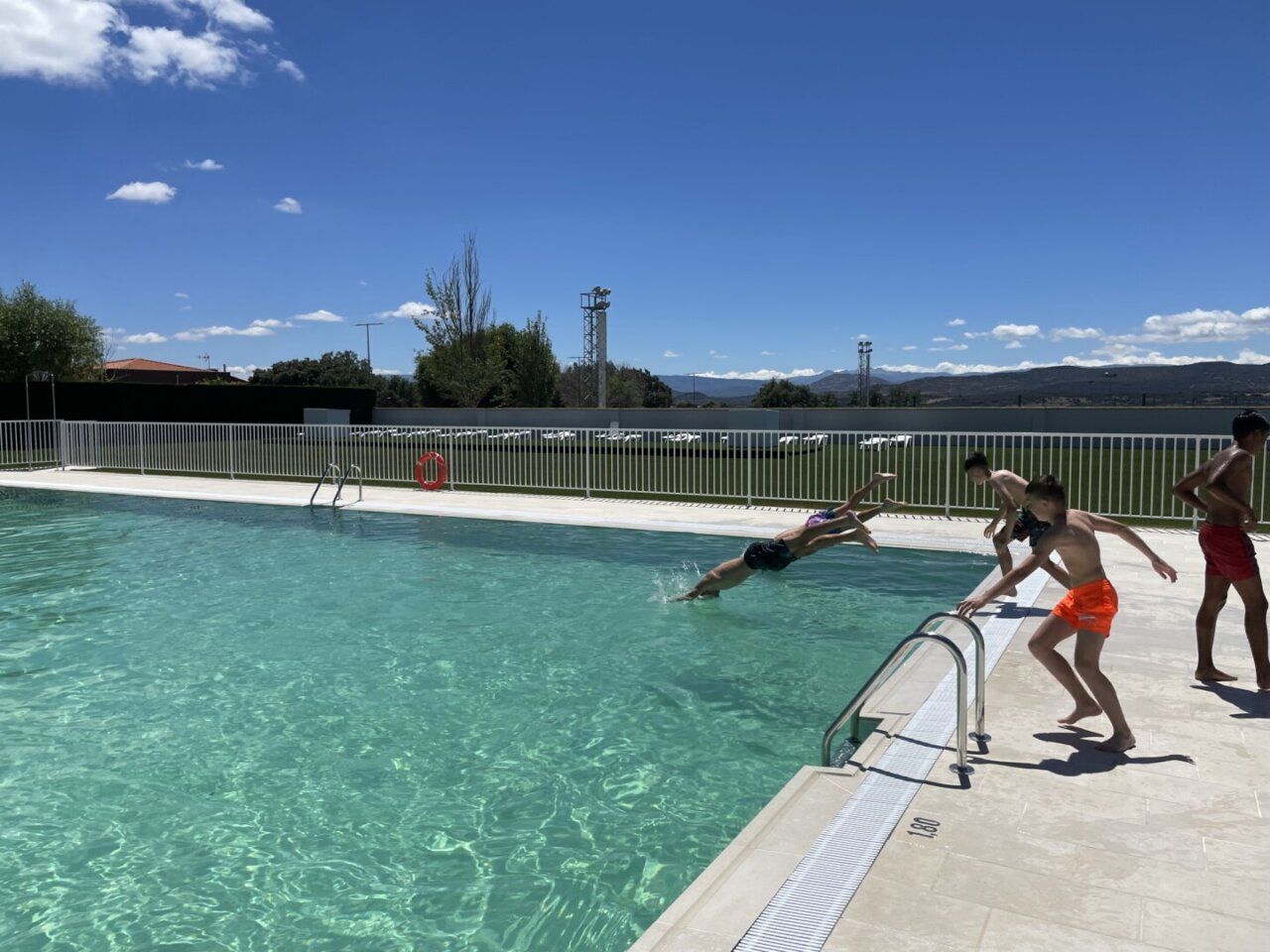 Niños disfrutando en la piscina municipal de Guijuelo bajo un cielo azul