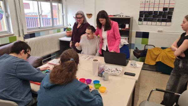 Grupo de personas en un aula trabajando en actividades educativas para autismo.