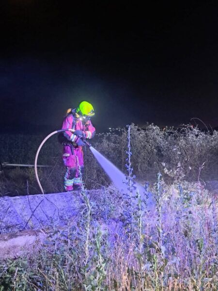 Bombero apagando un incendio en Pelabravo durante la noche