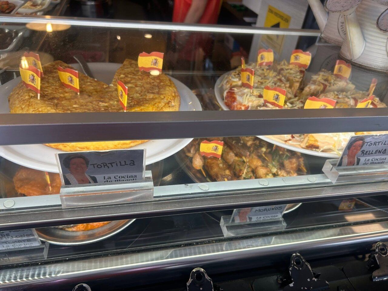 Platos de comida española en el Café Bar Chinitas con banderas de España.