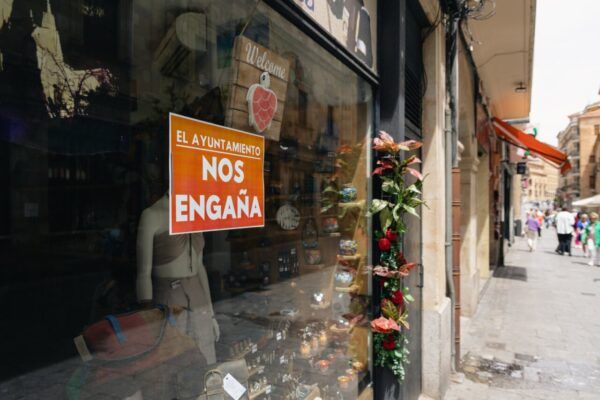 Vista de la calle Zamora con un cartel de protesta en una tienda