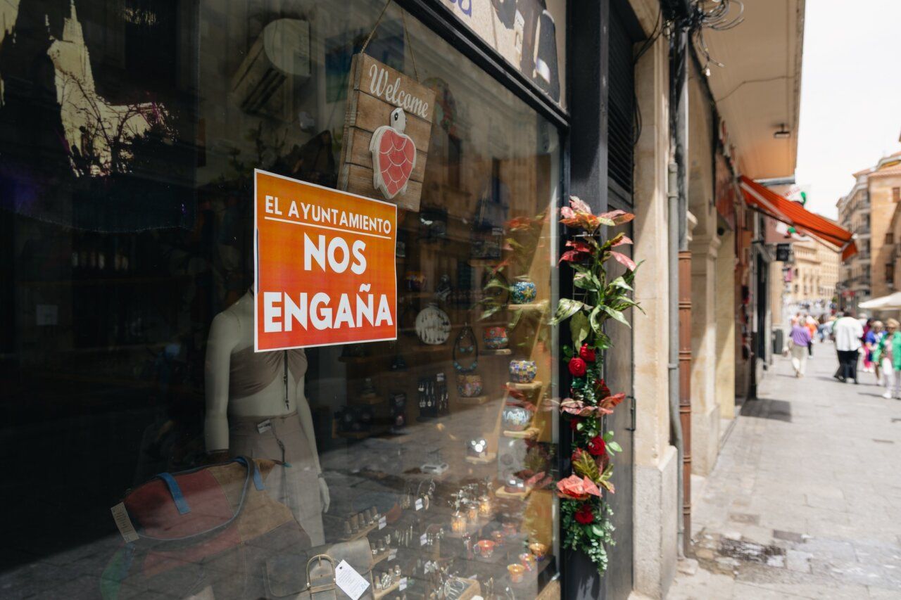 Vista de la calle Zamora con un cartel de protesta en una tienda