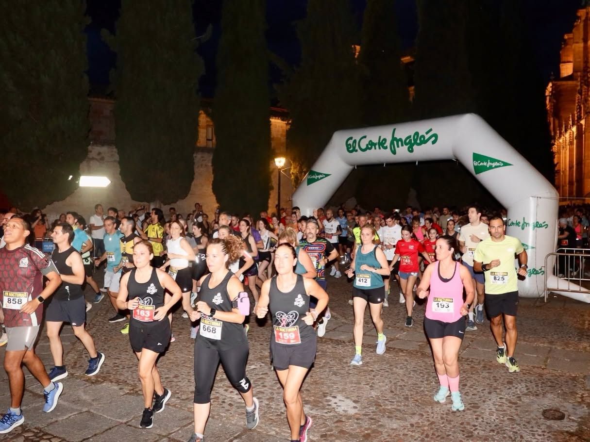 Participantes corriendo en la carrera popular en Salamanca bajo un arco de meta